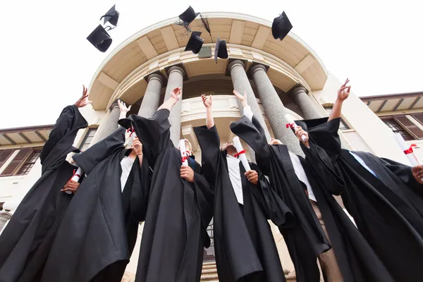 depositphotos_42492401-stock-photo-graduates-throwing-graduation-hats